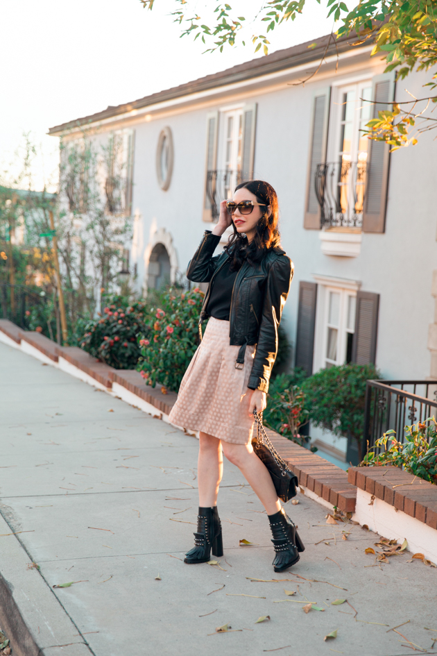 How to Dress Like a Londoner, styling tips featured by top LA fashion blog, Pretty Little Shoppers: image of a woman wearing Juicy Couture leather jacket, Alice & Olivia blouse, Anthropologie skirt, Tommy Hilfiger booties, and a Chanel bag.