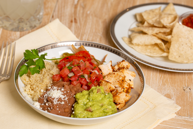 Mucho Delicious Bowl, Achiote Chicken, Quinoa, Refried Beans, Guacamole, Pico de Gallo, Sauteed Bell Peppers and Onions, Cojita Cheese