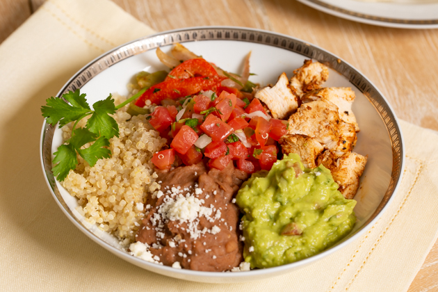 Mucho Delicious Bowl, Ahiote Chicken, Quinoa, Refried Beans, Guacamole, Pico de Gallo, Sauteed Bell Peppers and Onions, Cojita Cheese