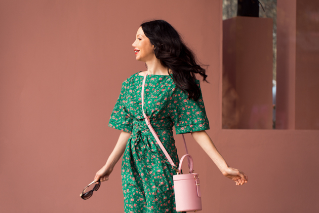 Green Floral Dress: a plus size summer outfit featuring a green floral dress  and wide fit straw hat from Torrid, and a dark green Kate Spade handbag.