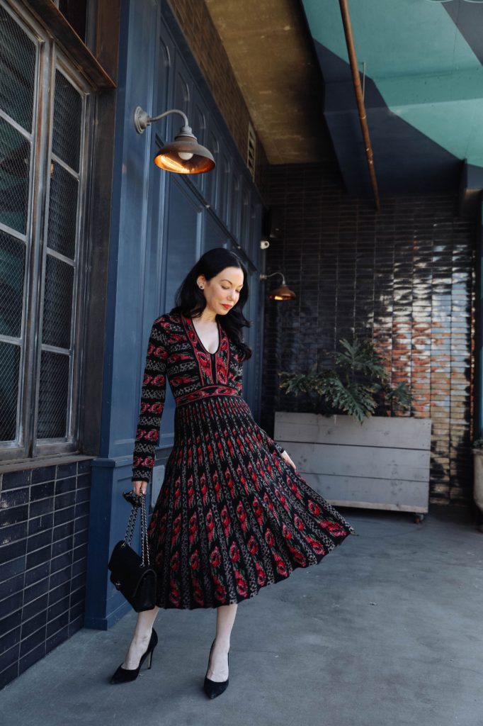 Weathering the Storm, Real Estate, Cecilia Prado, Winter Knit Dress, Winter Fashion Inspo, Los Angeles Fashion Blogger, Nuuly Rental Service, What to Wear in Winter, Gucci Sunglasses | Weathering the Storm by popular Los Angeles lifestyle blog, Pretty Little Shoppers: image of a woman wearing a Nuuly dress, Neiman Marcus heels, and holding a Chanel Lambskin & Gold-Tone Metal Black.