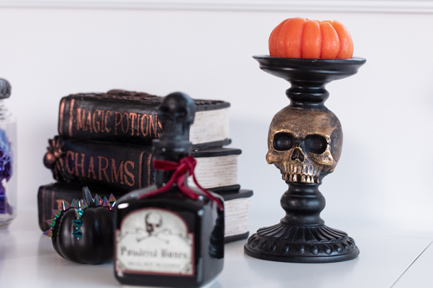 Celebrating Halloween In My New House, Halloween Ideas, How to Celebrate Halloween at Home, Halloween Ideas during Covid-19 Quarantine, Los Angeles Lifestyle Blogger, Pretty Little Shoppers Blog, Halloween Decorations #Halloween2020 |Cheese Platter by popular LA lifestyle blog, Pretty Little Shoppers: image of potion books, black apothecary jar, and skull stand with pumpkin shaped candle on it. 