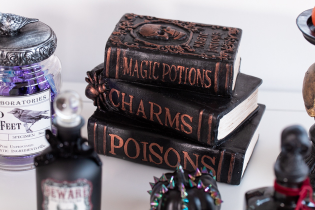 Halloween Spell and Poison Books Decoration |Cheese Platter by popular LA lifestyle blog, Pretty Little Shoppers: image of potion books, apothecary jars and a black pumpkin. 