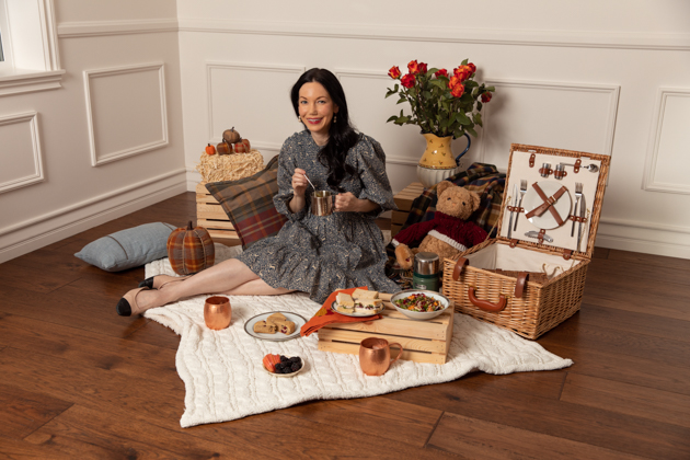 Indoor Fall Picnic, Fall Harvest Picnic Menu, Doen Fawn Dress, Lisa Valerie Morgan, Pretty Little Shoppers Blog, Los Angeles Lifestyle Blogger, How to Celebrate Thanksgiving During Quarantine, Holiday Ideas During Covid Quarantine #IndoorPicnic #ThanksgivingIdeas |Fall Picnic by popular LA lifestyle blog, Pretty Little Shoppers: image of a woman sitting on a knit cream blanket and having an indoor picnic. 