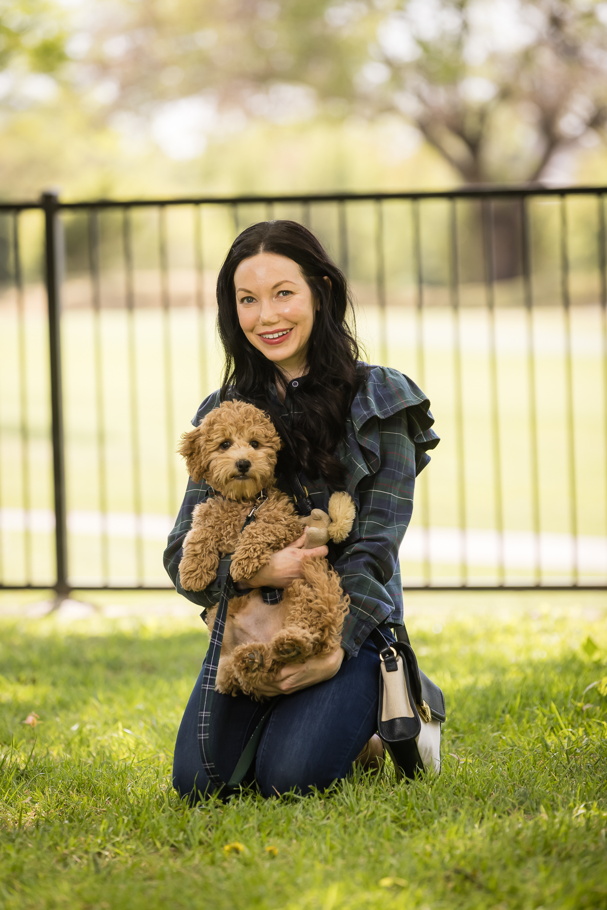 GoldenDoodle Puppy, Tartan Blouse, Tartan Bowtie and Leash, Meet My New Puppy, New Puppy Cuteness, Matching Mom and Dog Outfits, Pretty Little Shoppers Blog, Dallas Lifestyle Blog #GoldenDoodlePuppy #MeetMyPup |Charlie Cupcake by popular Dallas lifestyle blog, Pretty Little Shoppers: image of a woman wearing a plaid ruffle top and jeans and holding her goldendoodle puppy. 
