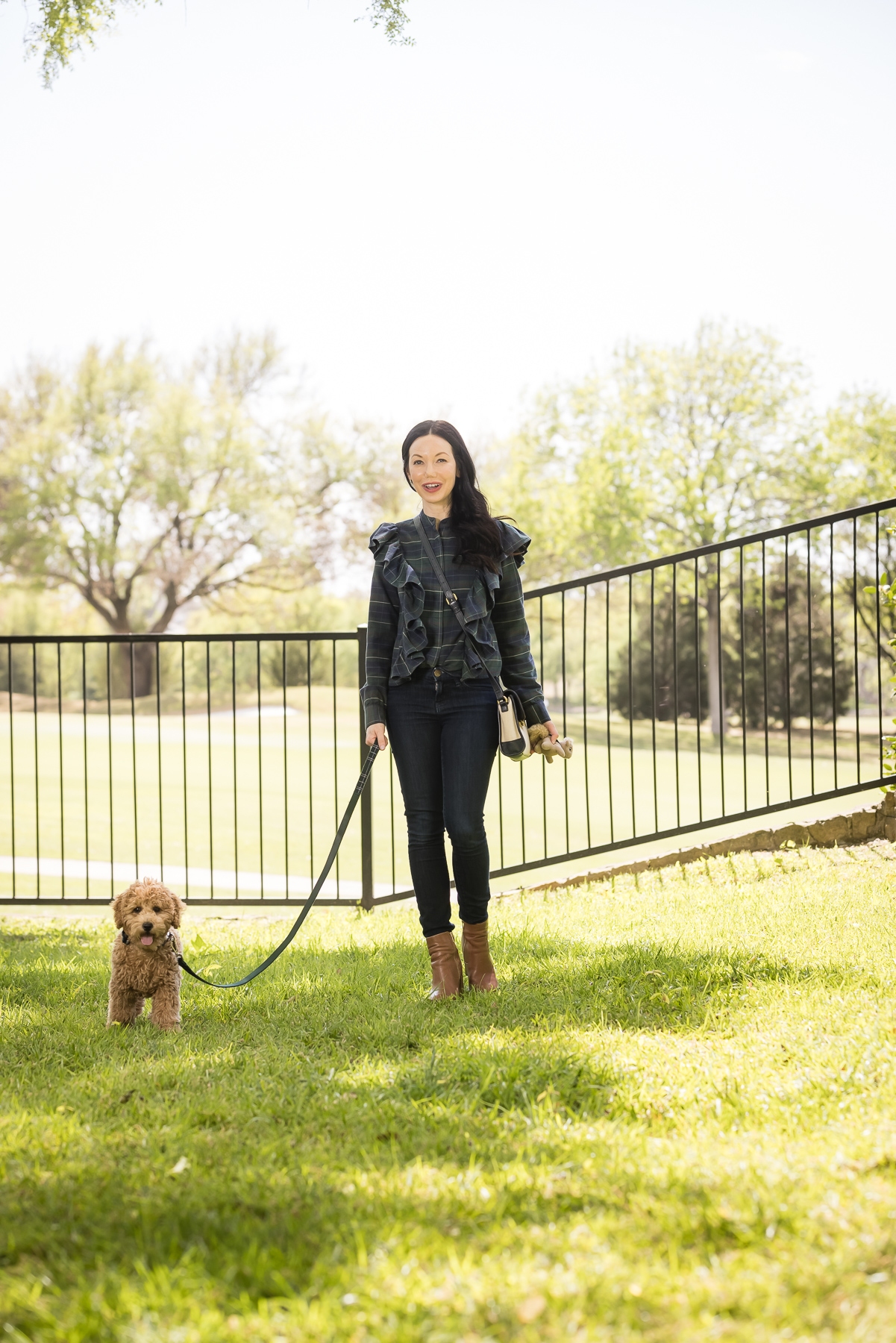 GoldenDoodle Puppy, Tartan Blouse, Tartan Bowtie and Leash, Meet My New Puppy, New Puppy Cuteness, Matching Mom and Dog Outfits, Pretty Little Shoppers Blog, Dallas Lifestyle Blog #GoldenDoodlePuppy #MeetMyPup |Charlie Cupcake by popular Dallas lifestyle blog, Pretty Little Shoppers: image of a woman wearing a plaid ruffle top and jeans and standing next to her goldendoodle puppy. 