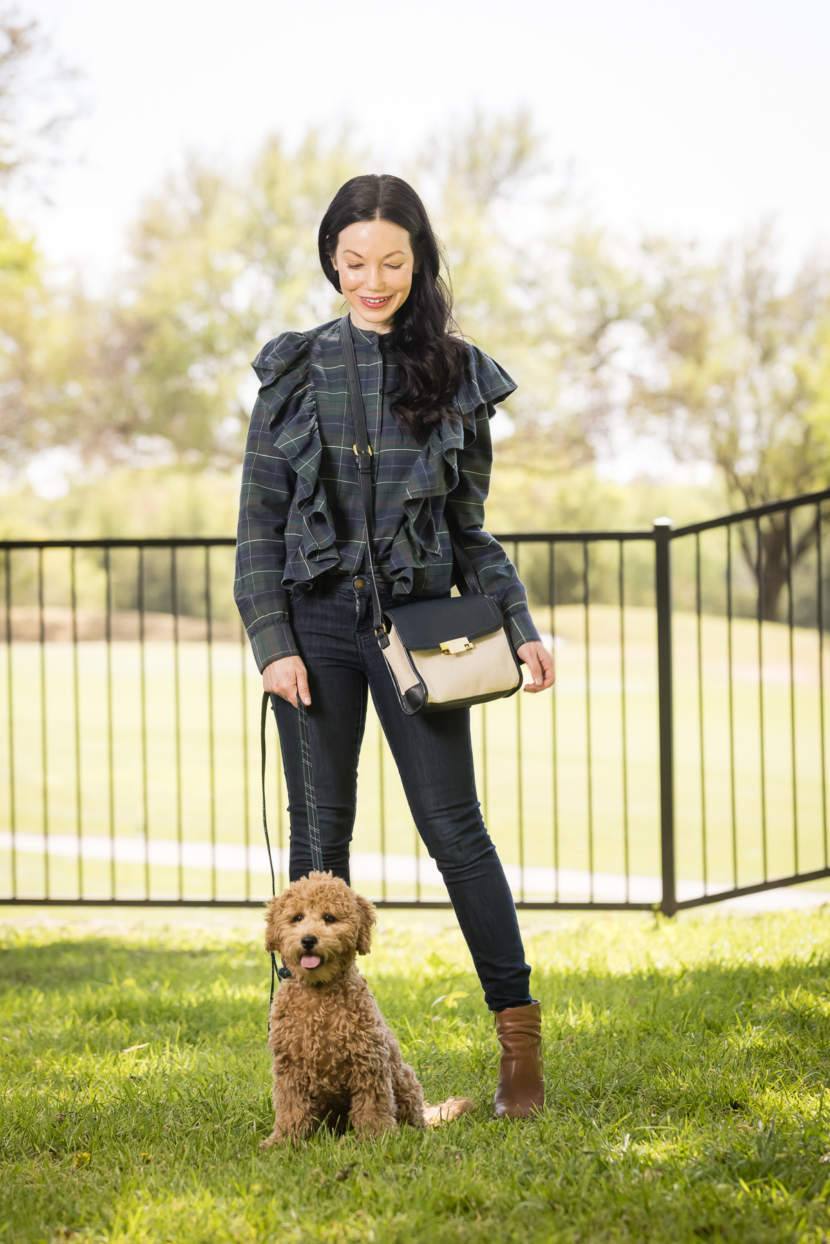 GoldenDoodle Puppy, Tartan Blouse, Tartan Bowtie and Leash, Meet My New Puppy, New Puppy Cuteness, Matching Mom and Dog Outfits, Pretty Little Shoppers Blog, Dallas Lifestyle Blog #GoldenDoodlePuppy #MeetMyPup |Charlie Cupcake by popular Dallas lifestyle blog, Pretty Little Shoppers: image of a woman wearing a plaid ruffle top and jeans and standing next to her goldendoodle puppy. 