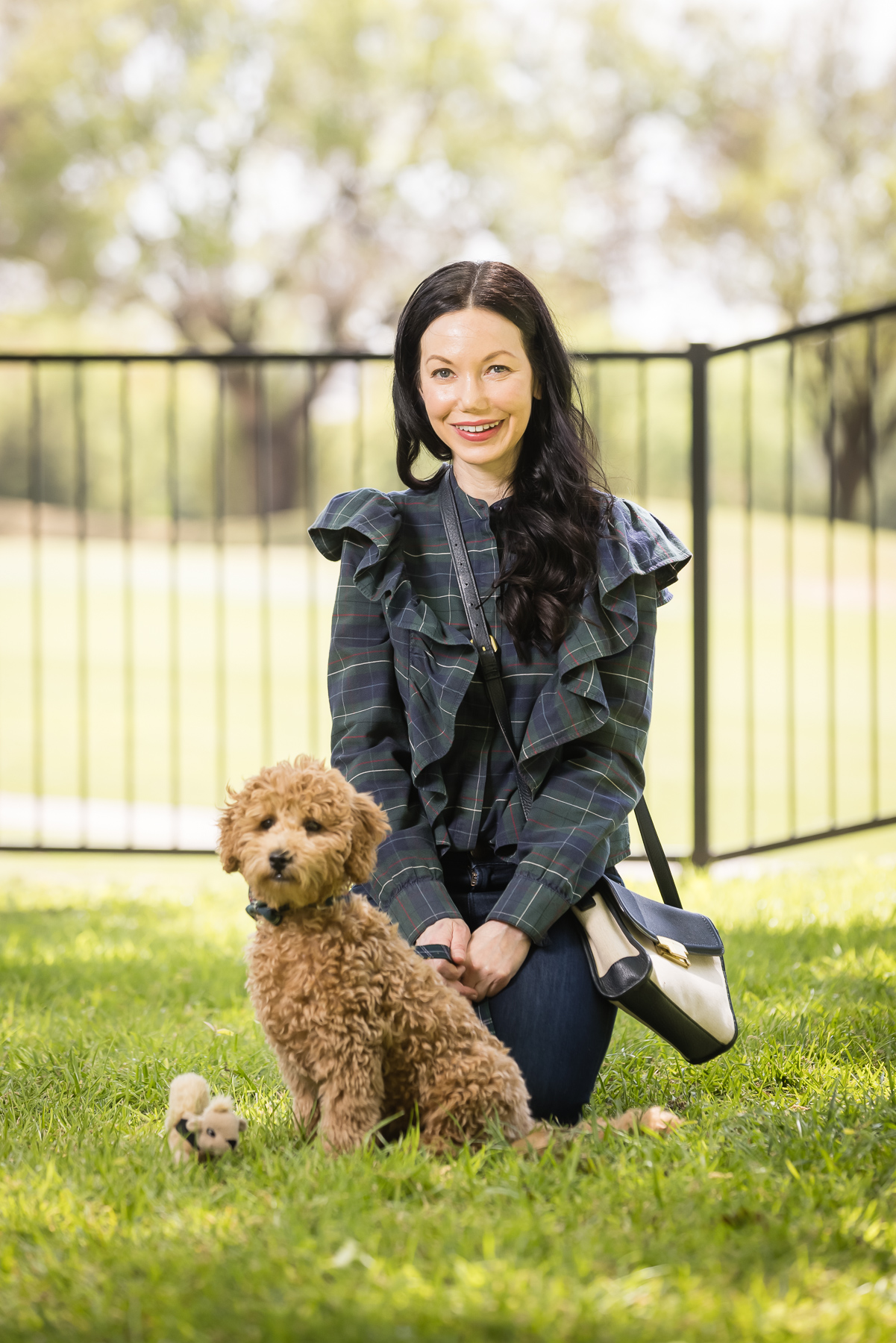 New Puppy, Baby Goldendoodle, Tartan Blouse, Denim, Matching Mom and Puppy outfit | Charlie Cupcake by popular Dallas lifestyle blog, Pretty Little Shoppers: image of a woman wearing a plaid ruffle top and jeans and kneeling next to her goldendoodle puppy. 