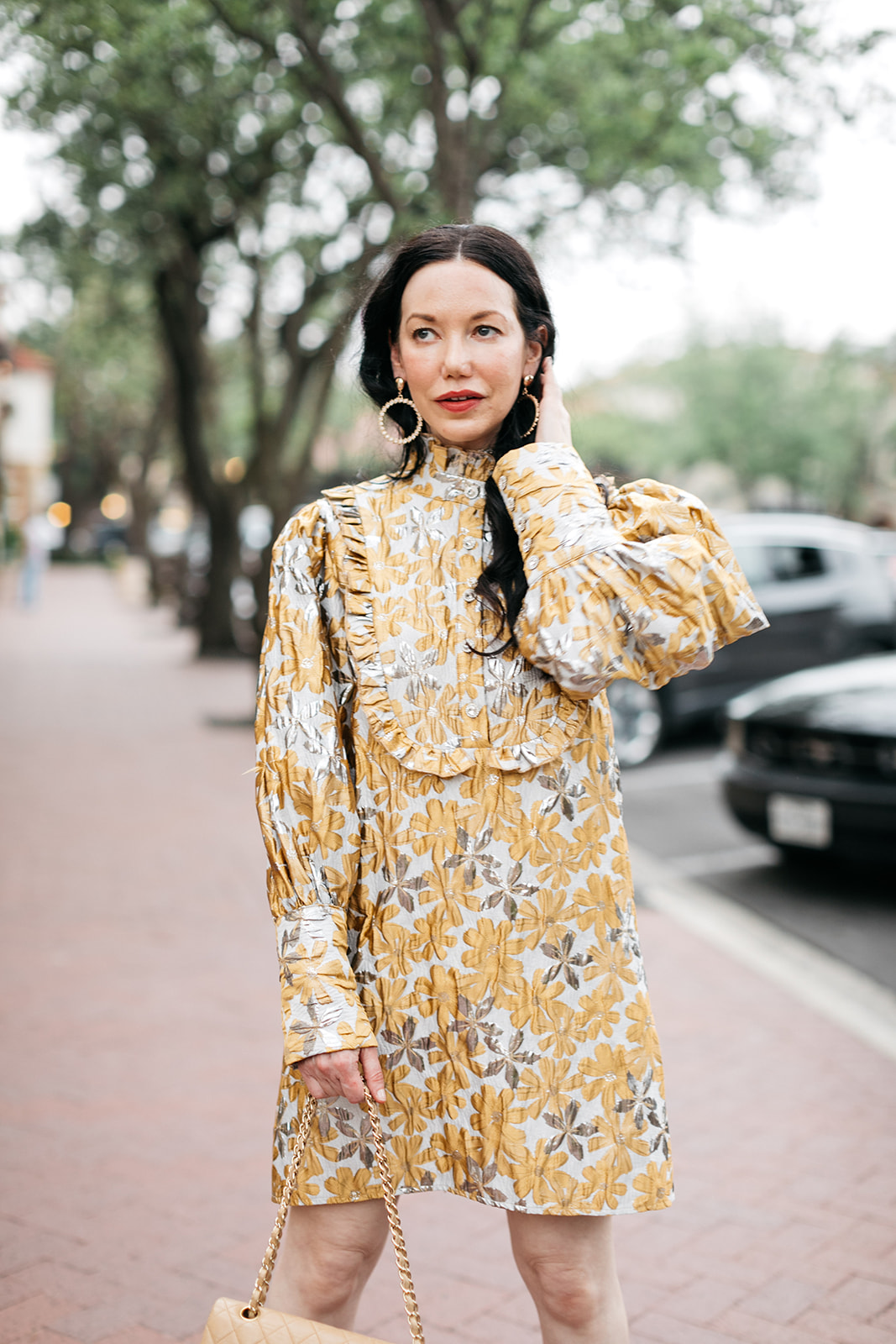 Ettika Gold Plated Statement Earrings, Sister Jane Cocktail Dress | Cocktail Dress by popular Dallas fashion blog, Pretty Little Shoppers: image of a woman walking outside on a brick paved sidewalk and wearing a Sister Jane Cocktail Dress, Chanel Bag, Jimmy Choo Sandals, and Ettika earrings.