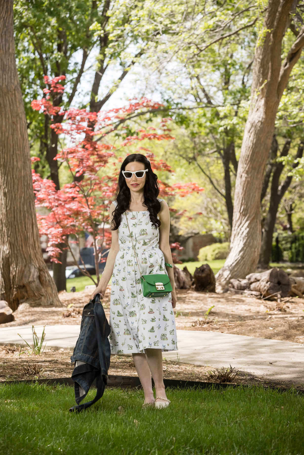 Sarah Patrick Collection Newport Topiary Gardens Dress, Furla Crossbody Bag, Italic Cat eye Sunglasses |Sarah Patrick Collection by popular Dallas fashion blog, Pretty Little Shoppers: image of a woman standing outside on some grass and wearing a Sarah Patrick Collection Newport Topiary Gardens Dress with Green Furla Crossbody Bag.