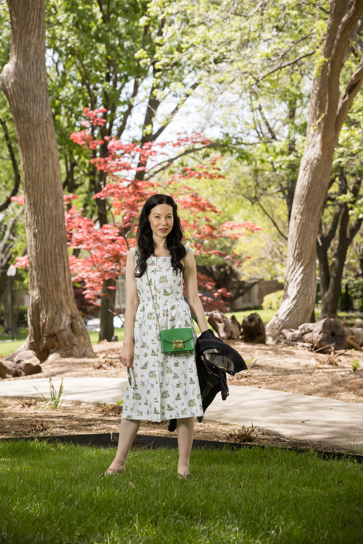 Fashion Blogger, Sundress, Sarah Patrick Collection, Furla crossbody bag |Sarah Patrick Collection by popular Dallas fashion blog, Pretty Little Shoppers: image of a woman standing outside on some grass and wearing a Sarah Patrick Collection Newport Topiary Gardens Dress with Green Furla Crossbody Bag.