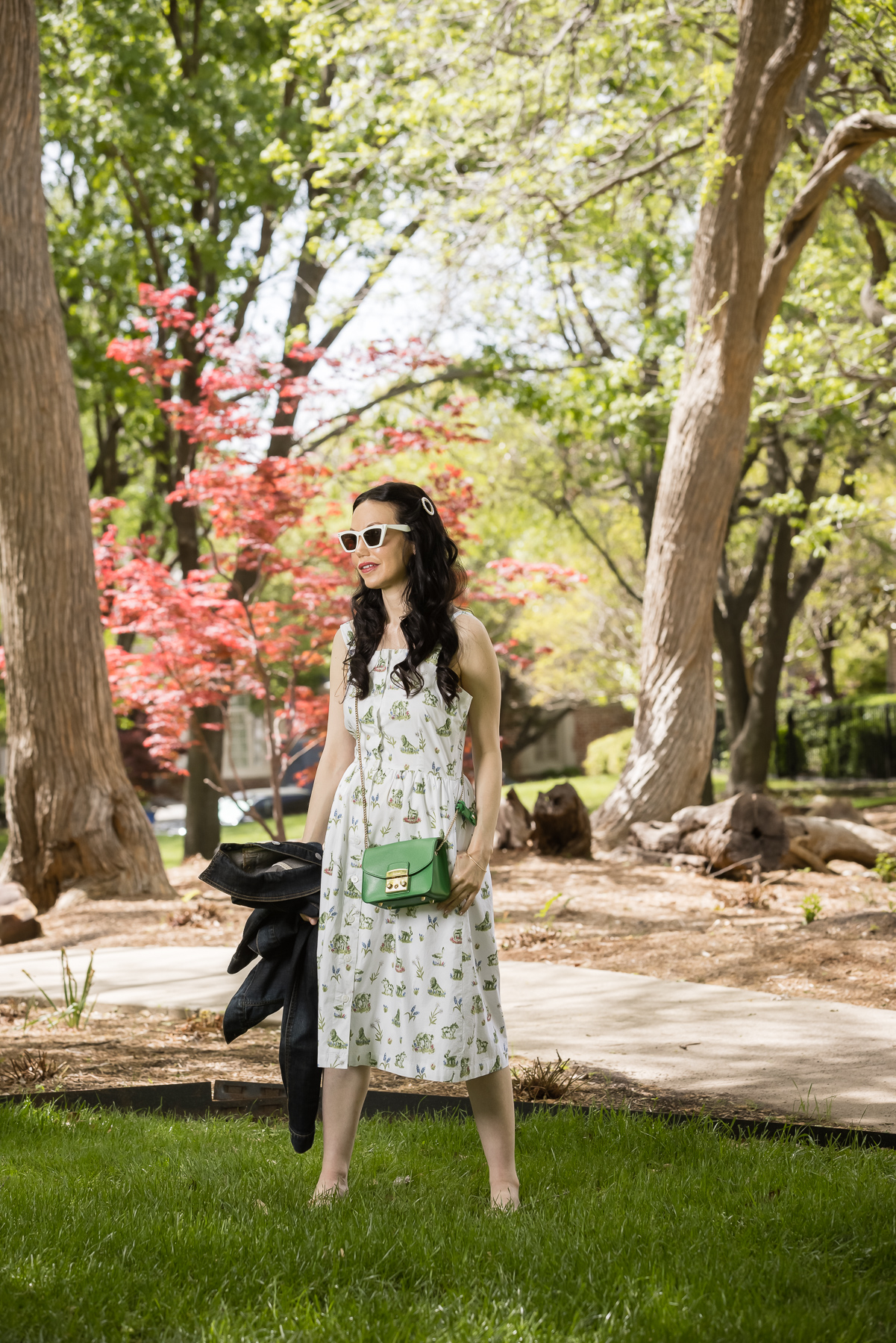 Sarah Patrick Collection Newport Topiary Gardens Dress, Italic Cateye Sunglasses, Green Mini Furla Crossbody Bag |Sarah Patrick Collection by popular Dallas fashion blog, Pretty Little Shoppers: image of a woman standing outside on some grass and wearing a Sarah Patrick Collection Newport Topiary Gardens Dress with Green Furla Crossbody Bag.