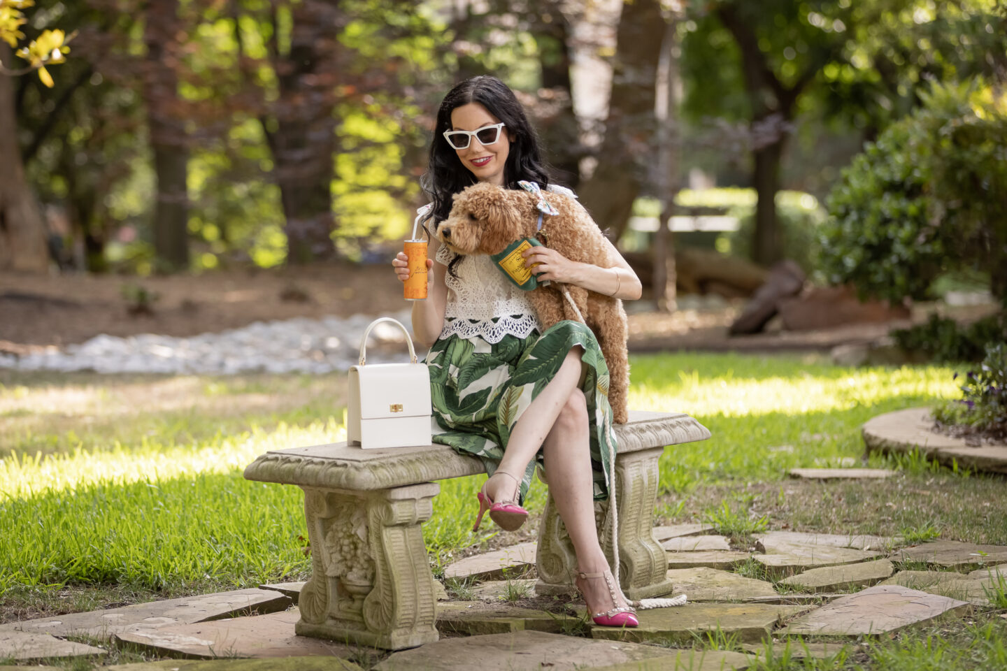 Palm Print Skirt, Neely & Chloe Bag, White Lace Top, Pink Pumps, Fashion Blogger, Fall Transitional Style, Mini Goldendoodle puppy, Fashion Blogger, Presto Sparkling Cuvee | Palm Print Skirt by popular Dallas fashion blog, Pretty Little Shoppers: image of a woman holding her dog outside and wearing a palm print skirt, lace cropped top, and pink heels. 