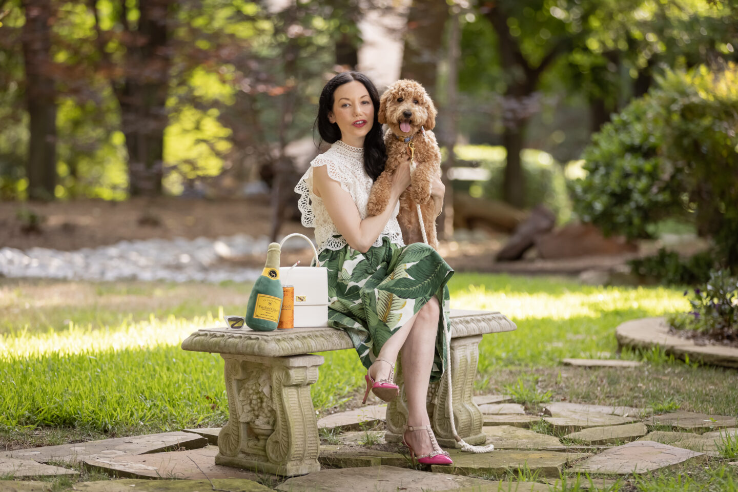 Palm Print Skirt, White Lace Top, Pink Pumps, Fashion Blogger, Fall Transitional Style, Mini Goldendoodle puppy, Fashion Blogger, Presto Sparkling Cuvee | Palm Print Skirt by popular Dallas fashion blog, Pretty Little Shoppers: image of a woman holding her dog outside and wearing a palm print skirt, lace cropped top, and pink heels. 